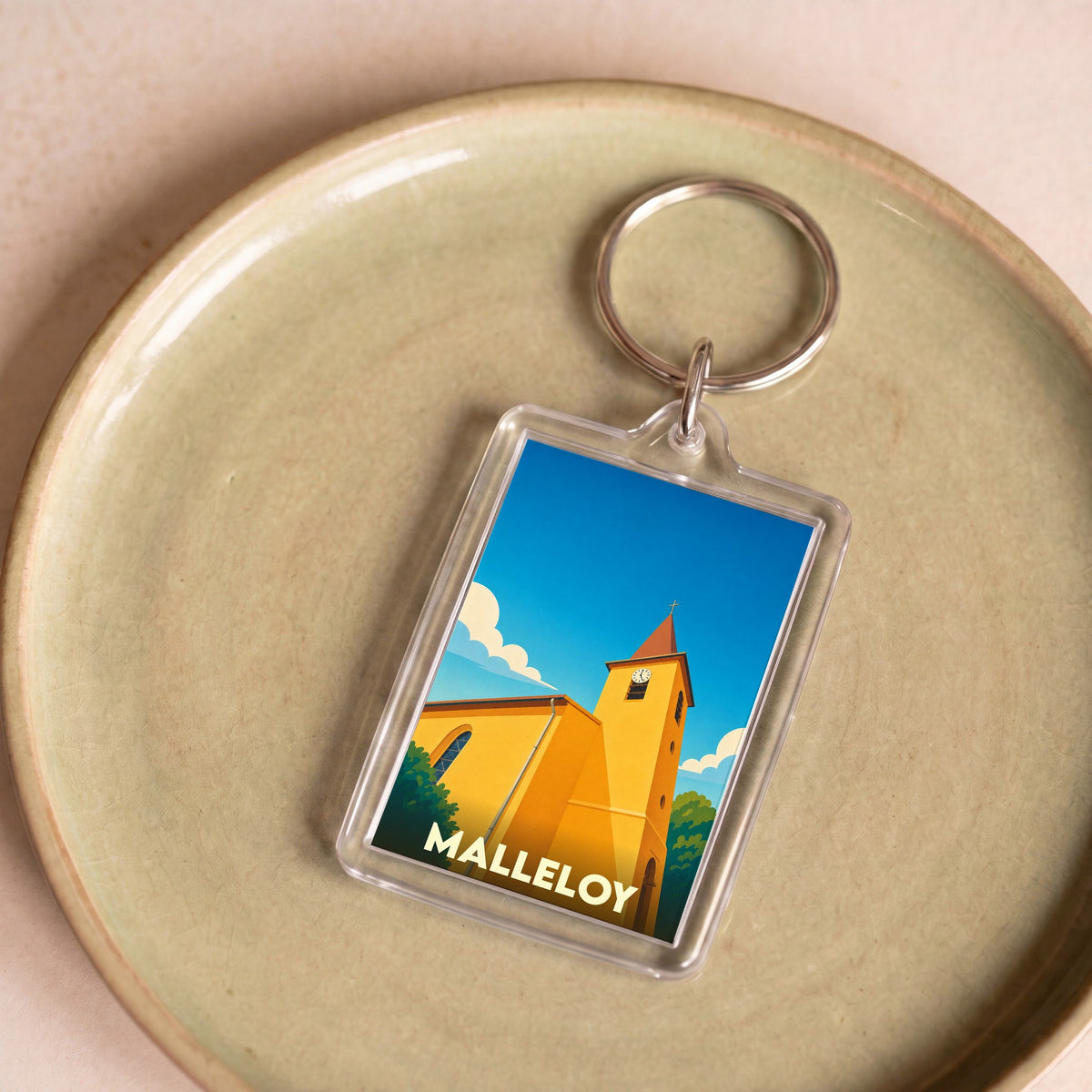 Porte-clés souvenir de la ville de Malleloy avec une illustration stylisée de son église.