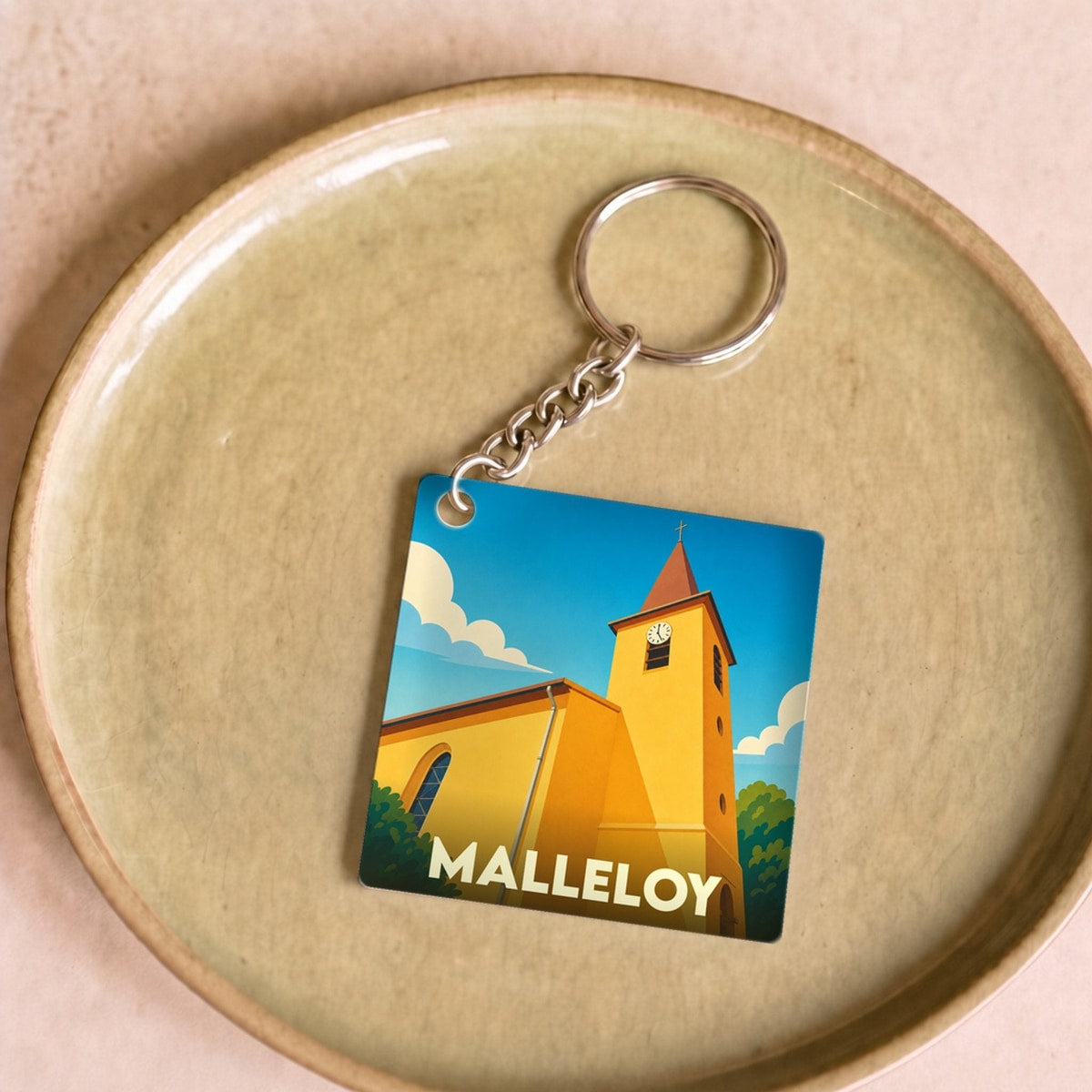 Porte-clés souvenir de la ville de Malleloy avec une illustration stylisée de son église.