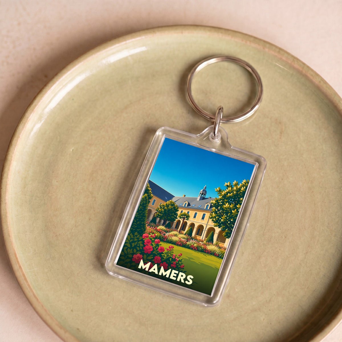 Porte-clés souvenir de la ville de Mamers avec une illustration stylisée.