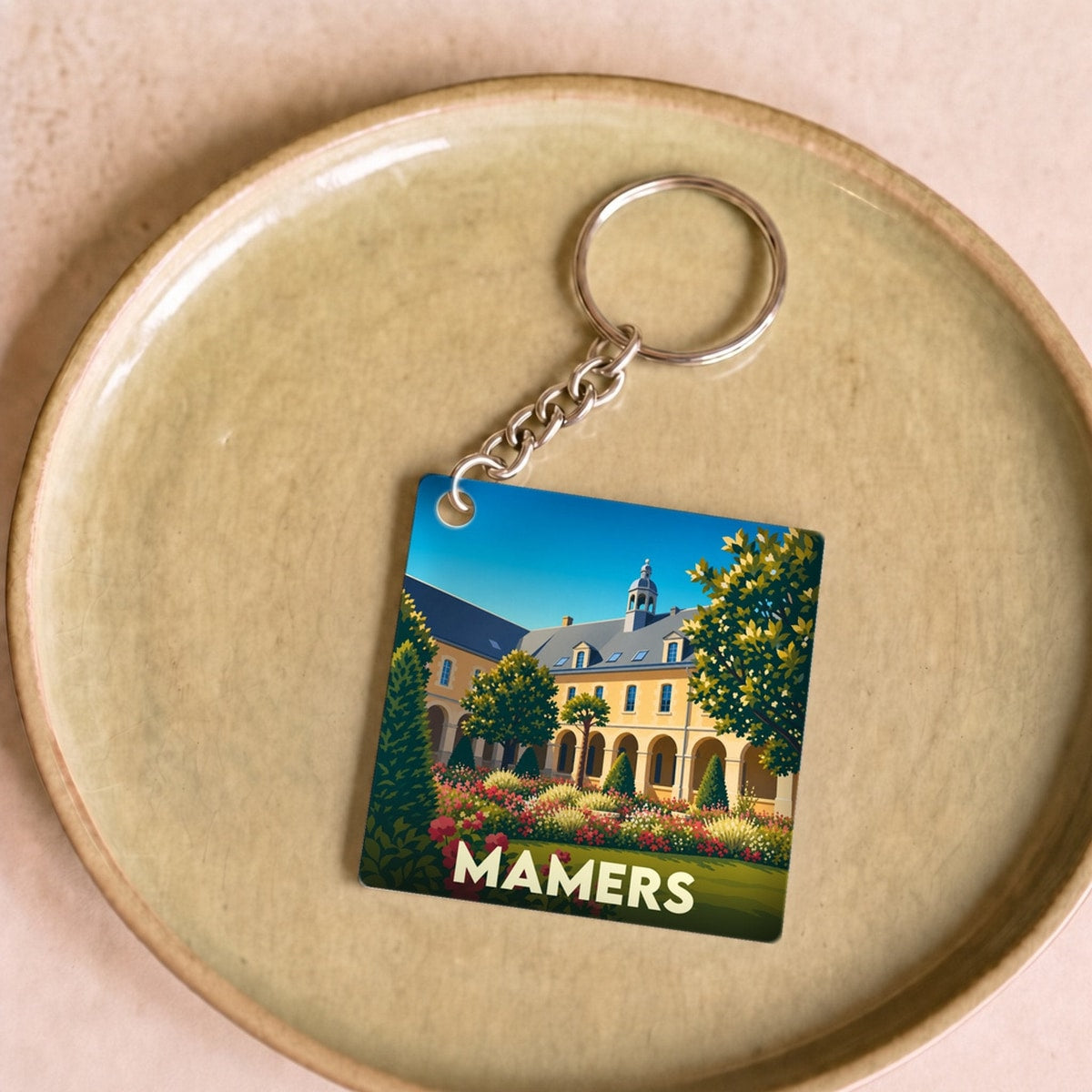 Porte-clés souvenir de la ville de Mamers avec une illustration stylisée.