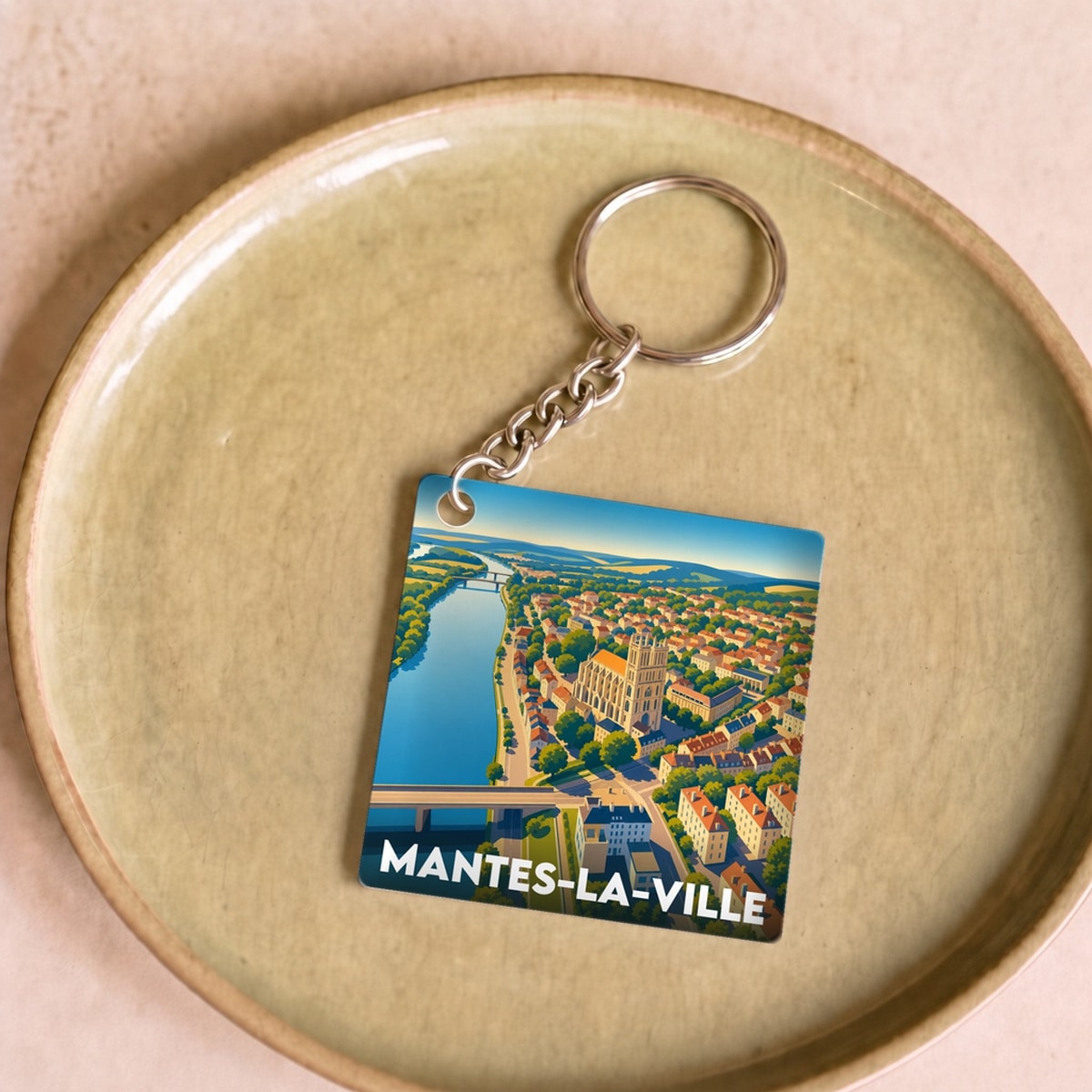Porte-clés souvenir de la ville de Mantes-la-Ville avec une illustration stylisée.