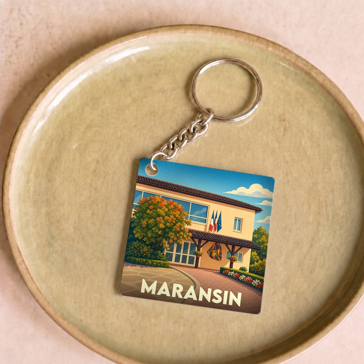 Porte-clés souvenir de la ville de Maransin avec une illustration stylisée.