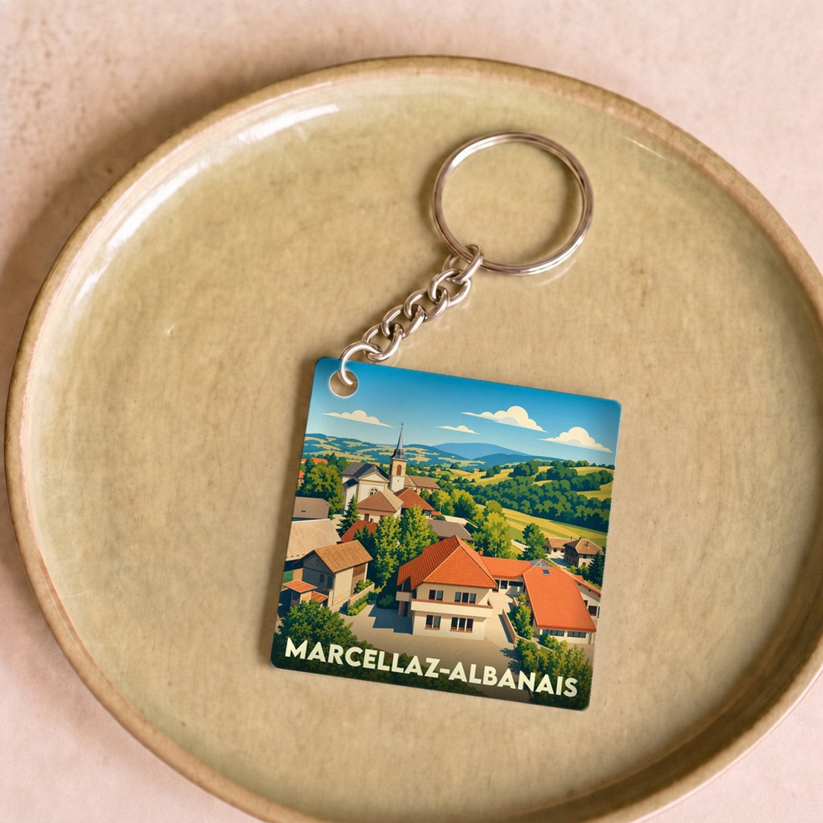 Porte-clés souvenir de la ville de Marcellaz-Albanais avec une illustration stylisée.