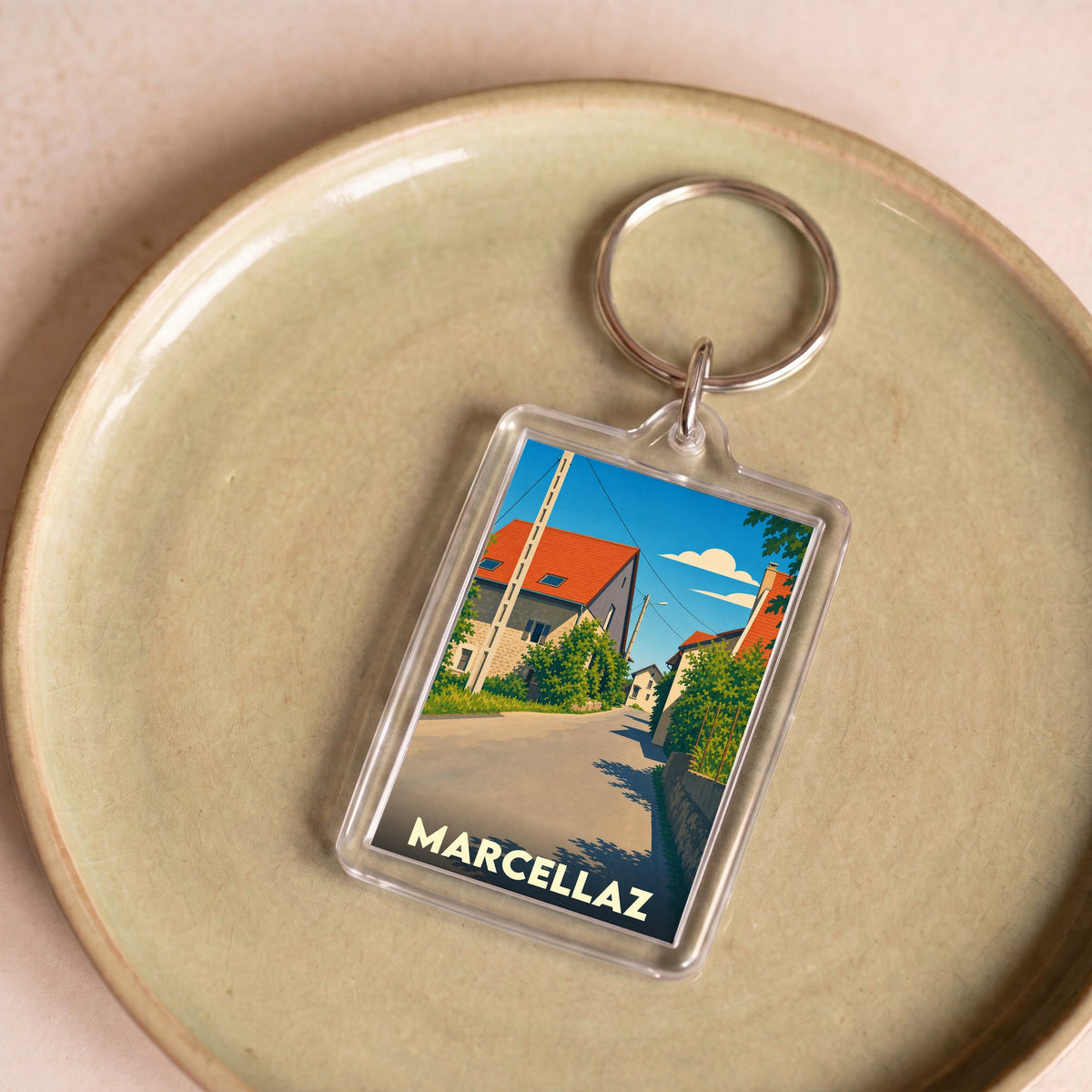 Porte-clés souvenir de la ville de Marcellaz avec une illustration stylisée de ses maisons.
