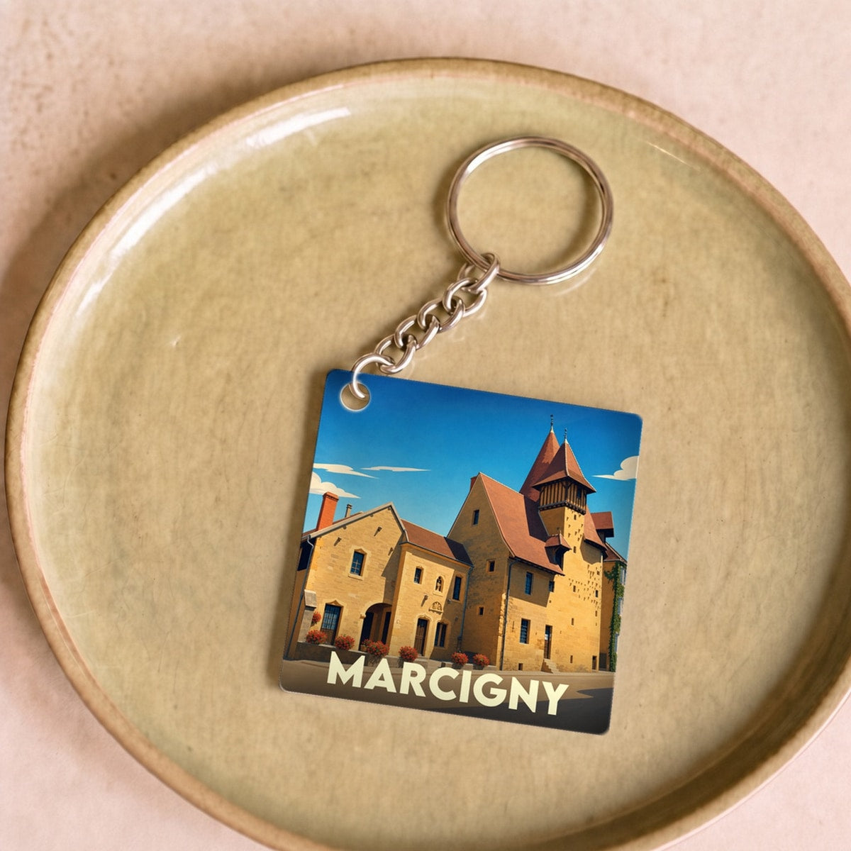 Porte-clés souvenir de la ville de Marcigny avec une illustration stylisée de son architecture historique.