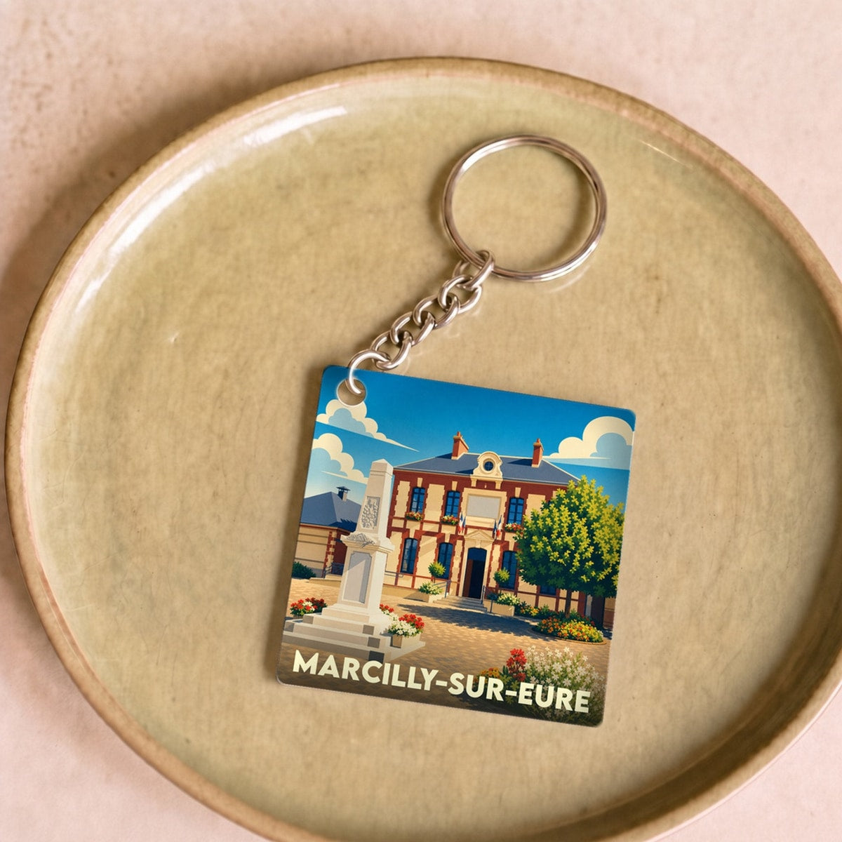 Porte-clés souvenir de la ville de Marcilly-sur-Eure avec une illustration stylisée.