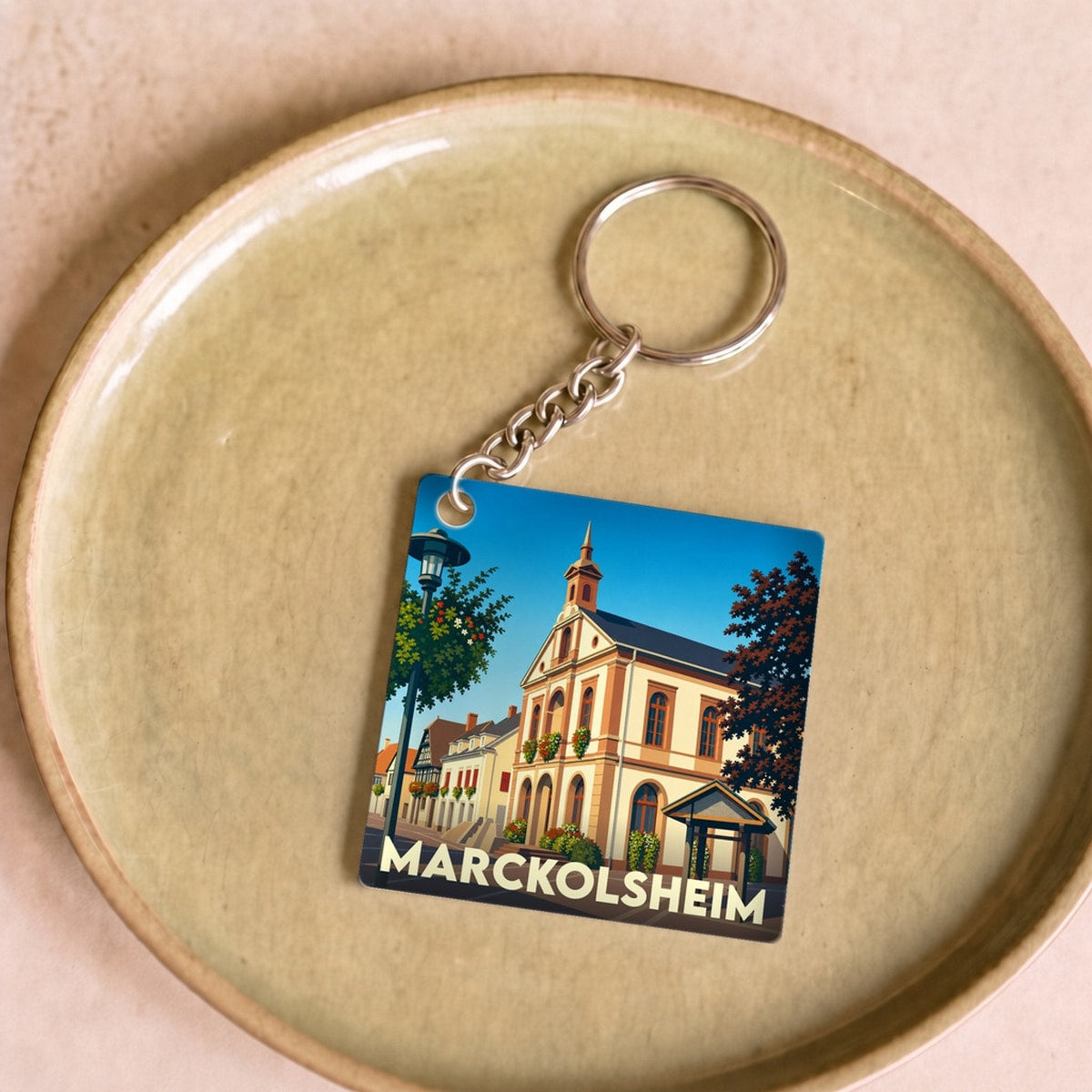 Porte-clés souvenir de la ville de Marckolsheim avec une illustration stylisée.