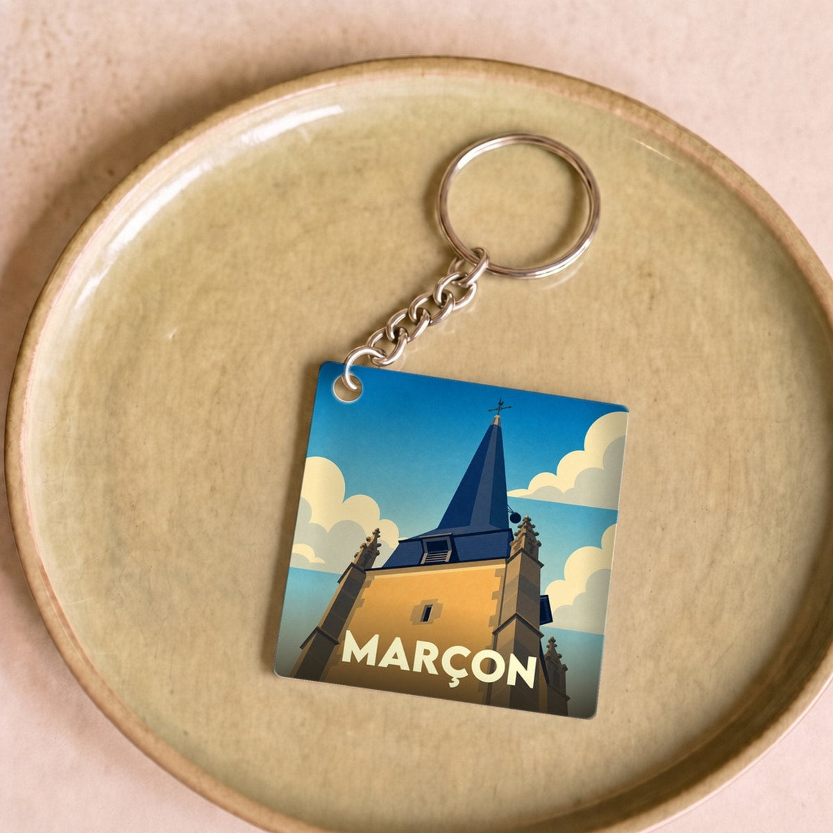 Porte-clés souvenir de la ville de Marçon avec une illustration stylisée de son clocher.
