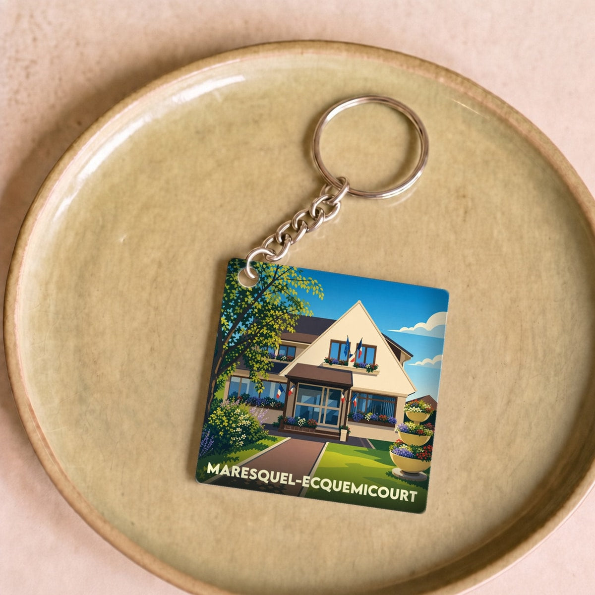 Porte-clés souvenir de la ville de Maresquel-Ecquemicourt avec une illustration stylisée de sa mairie.