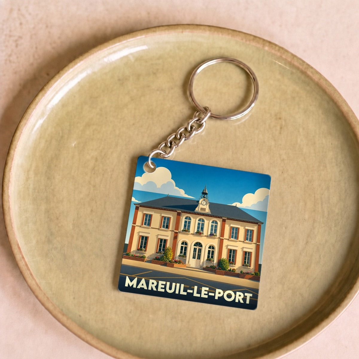 Porte-clés souvenir de la ville de Mareuil-le-Port avec une illustration stylisée de sa mairie.