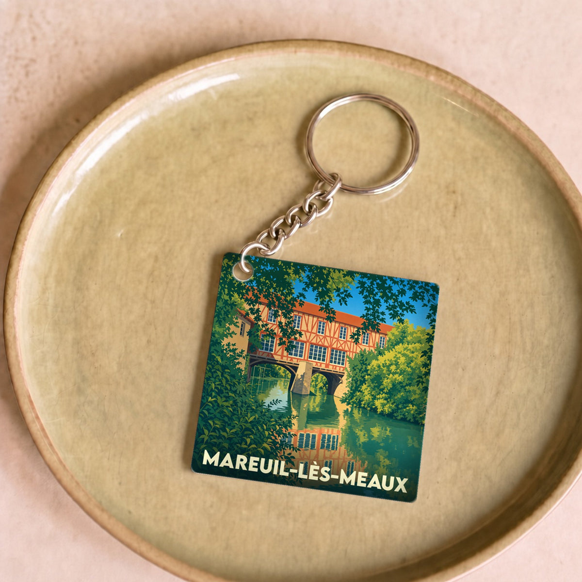 Porte-clés souvenir de la ville de Mareuil-lès-Meaux avec une illustration stylisée.