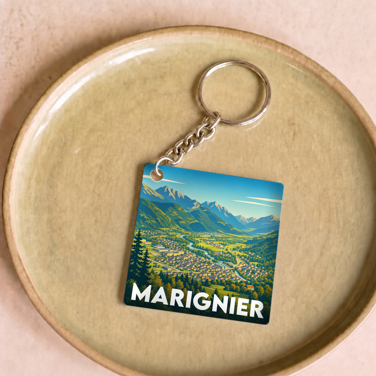 Porte-clés souvenir de la ville de Marignier avec une illustration stylisée de ses montagnes et de sa vallée.