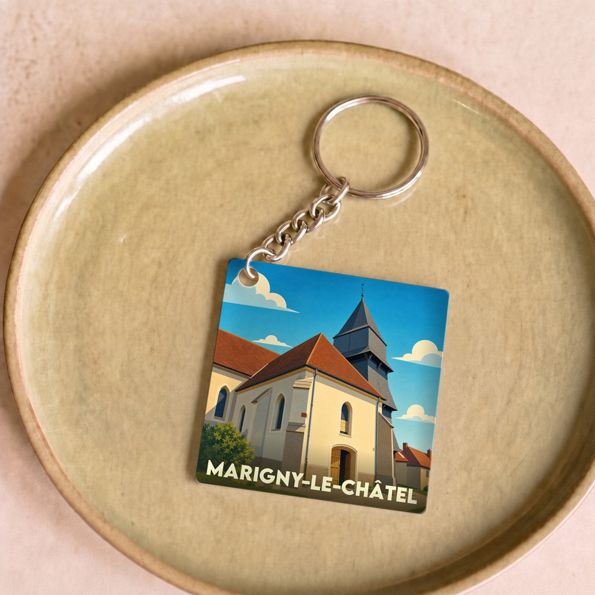 Porte-clés souvenir de Marigny-le-Châtel avec une illustration stylisée de son église.