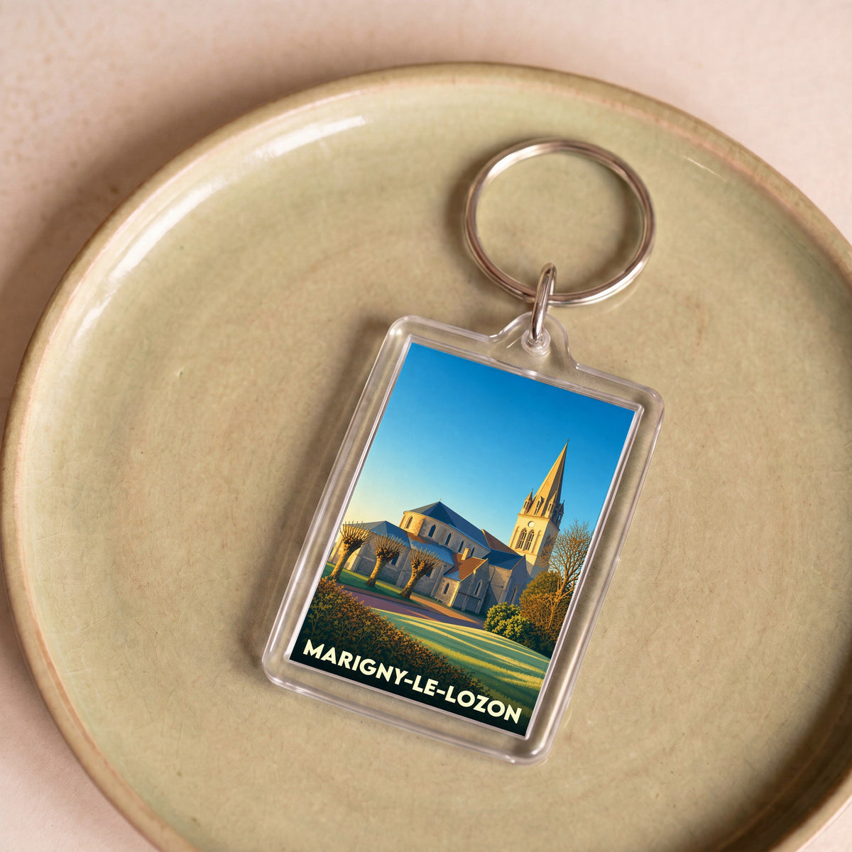 Porte-clés souvenir de la ville de Marigny-Le-Lozon avec une illustration stylisée de son église.