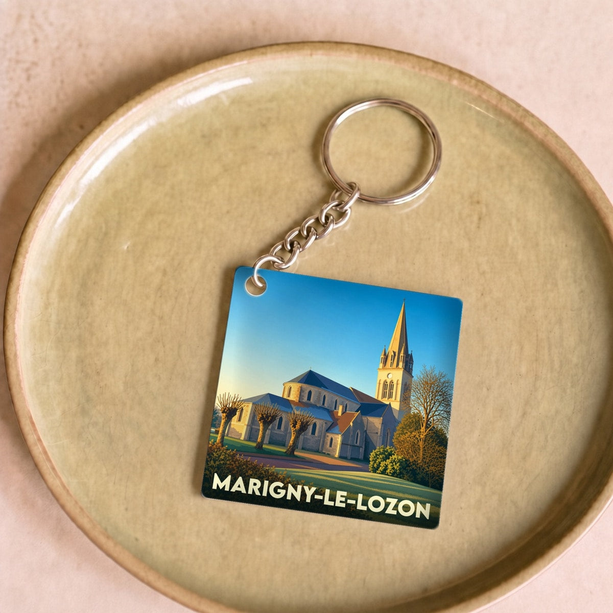 Porte-clés souvenir de la ville de Marigny-Le-Lozon avec une illustration stylisée de son église.