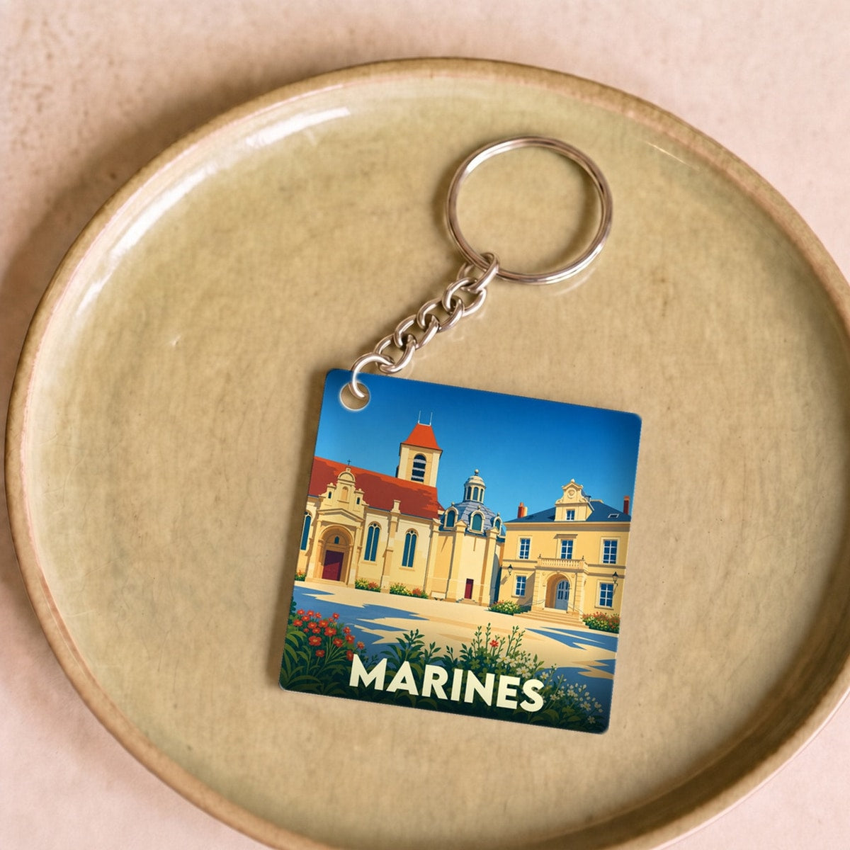 Porte-clés souvenir de la ville de Marines avec une illustration stylisée de son patrimoine architectural.
