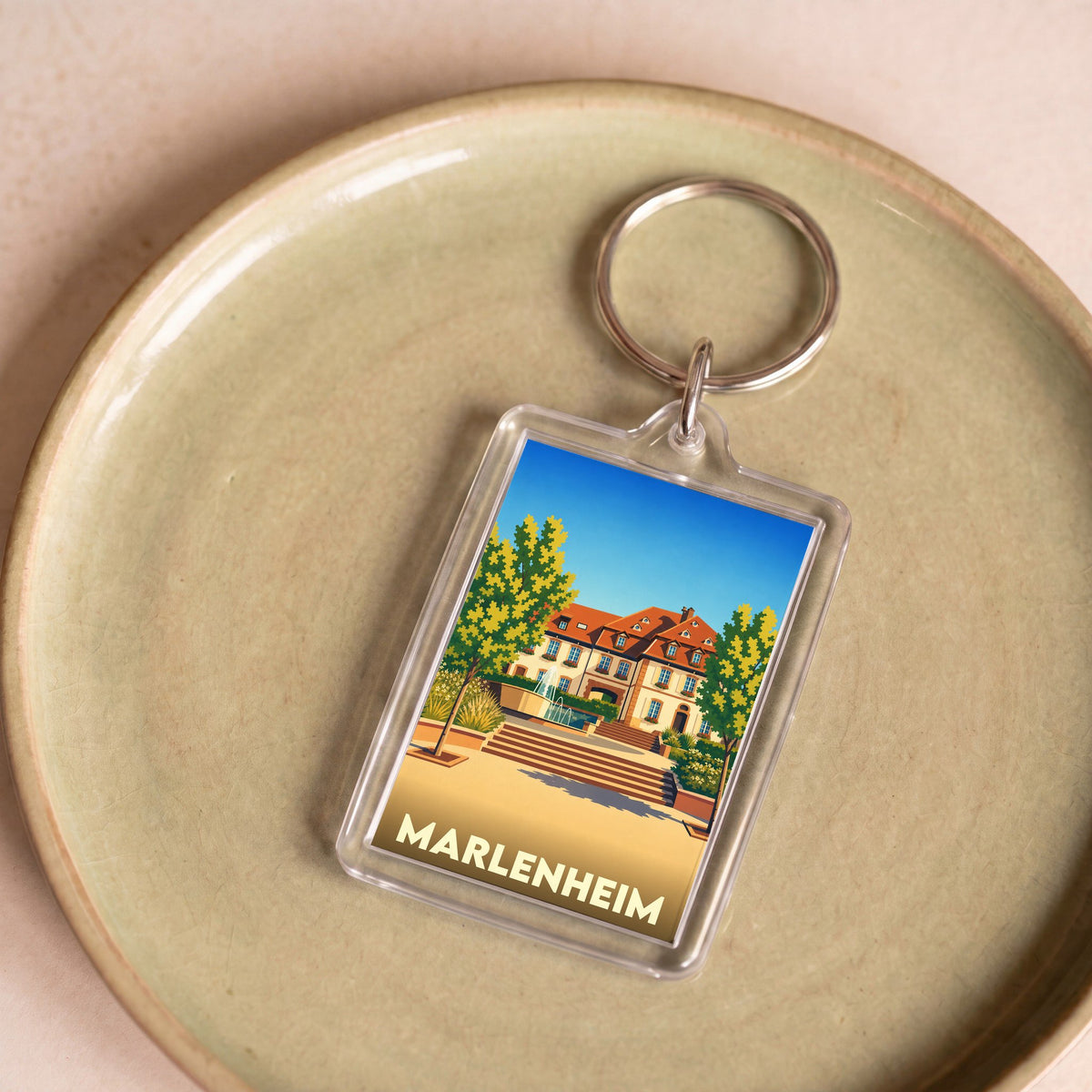 Porte-clés souvenir de la ville de Marlenheim avec une illustration stylisée d'une demeure traditionnelle alsacienne.