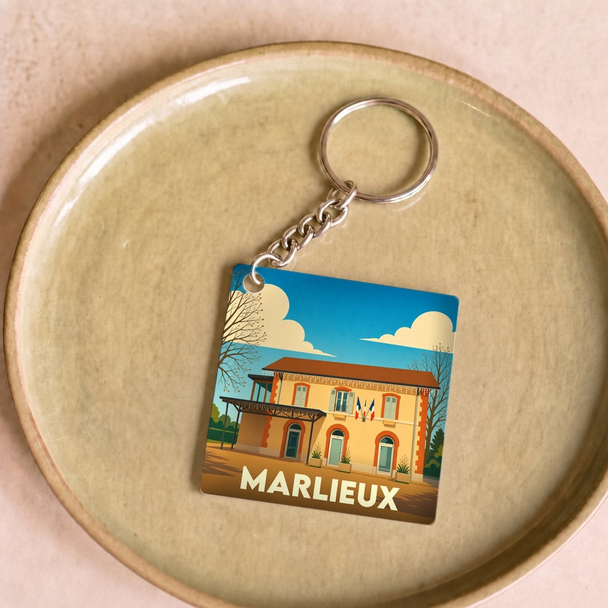 Porte-clés souvenir de la ville de Marlieux avec une illustration stylisée.