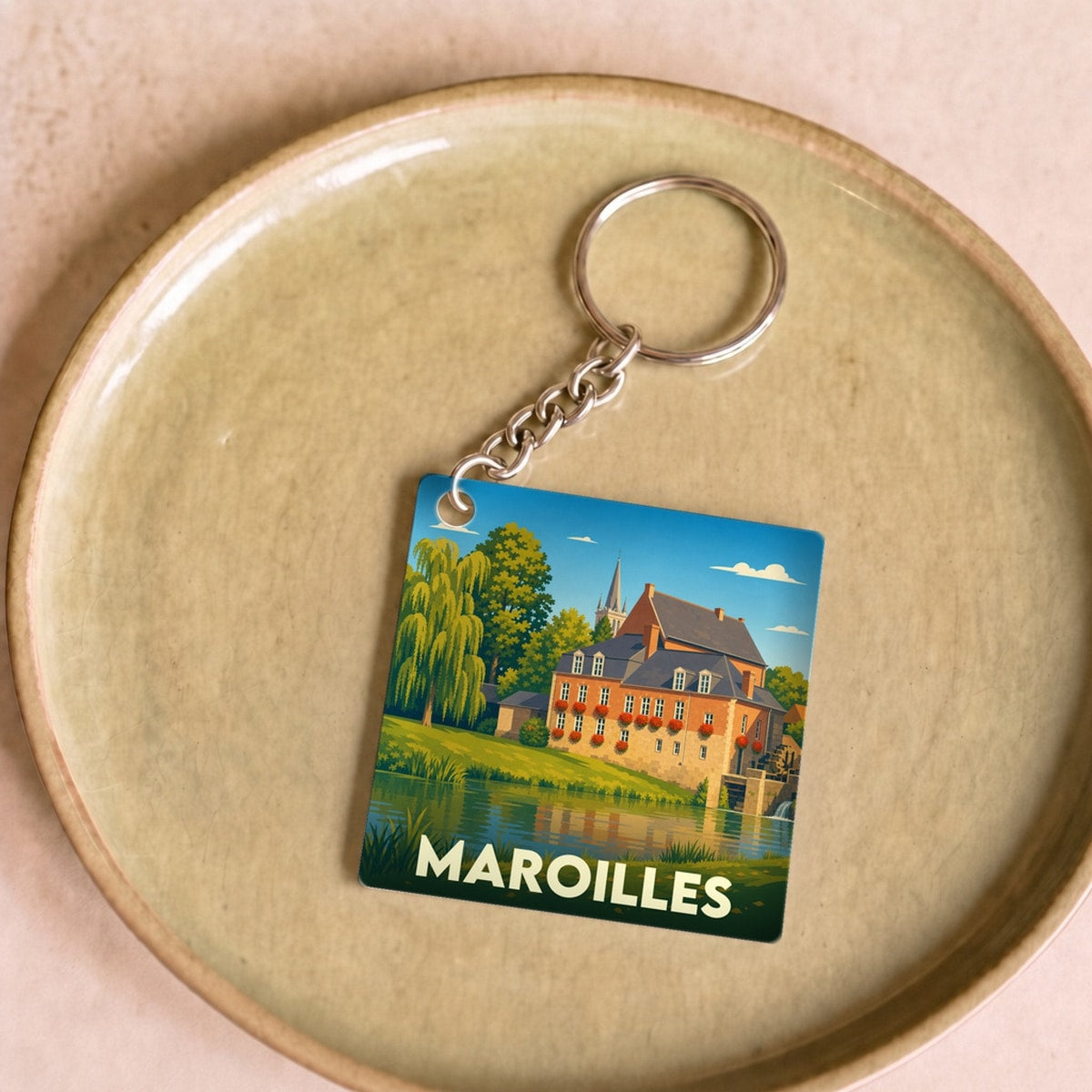 Porte-clés souvenir de la ville de Maroilles avec une illustration stylisée.