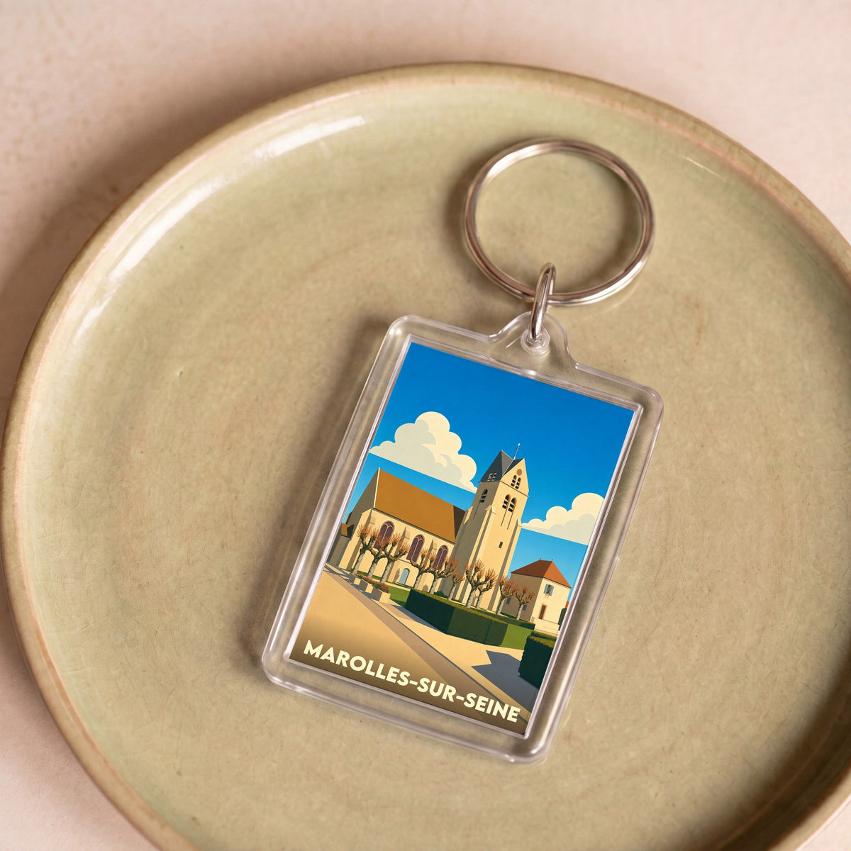 Porte-clés souvenir de la ville de Marolles-sur-Seine avec une illustration stylisée de son église.