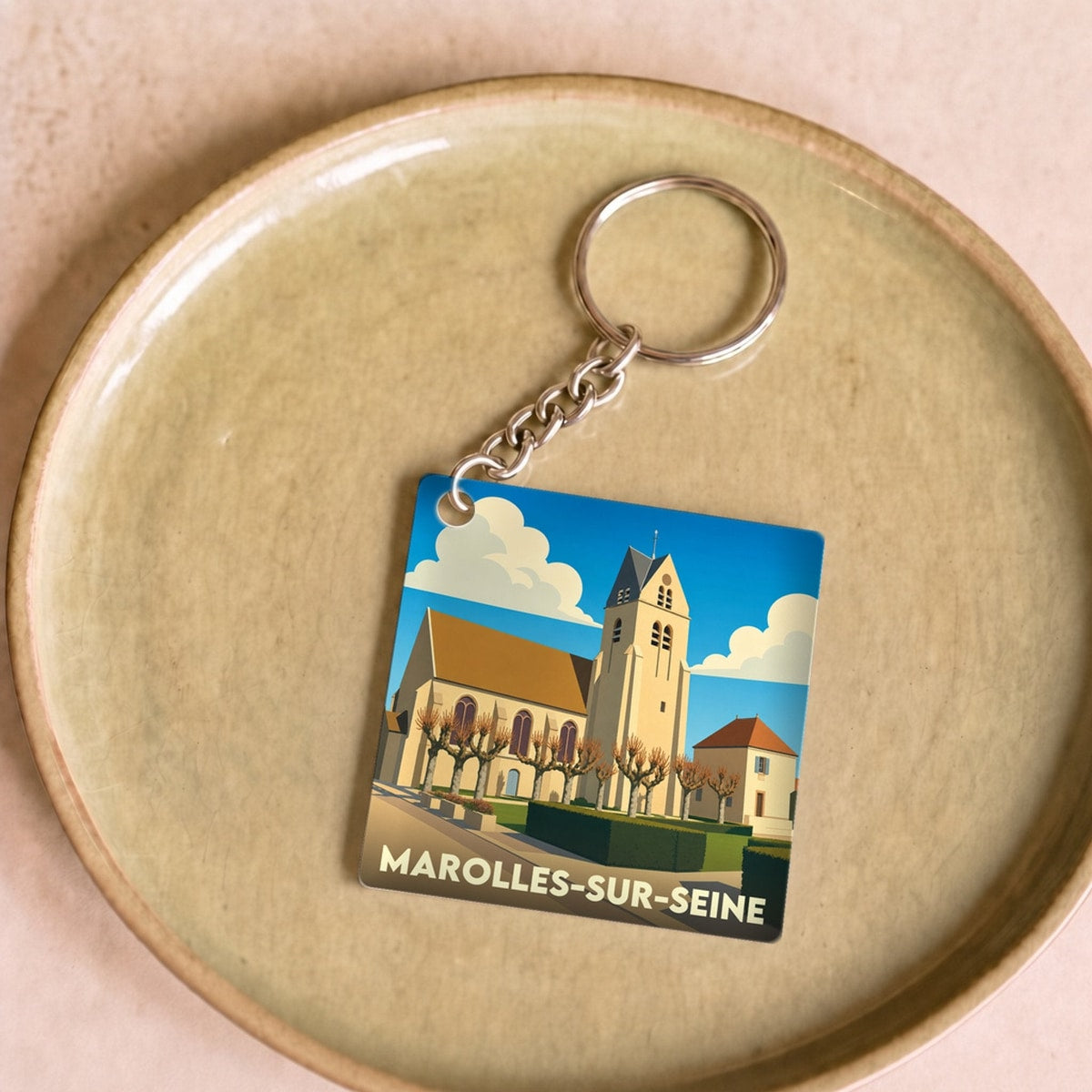 Porte-clés souvenir de la ville de Marolles-sur-Seine avec une illustration stylisée de son église.