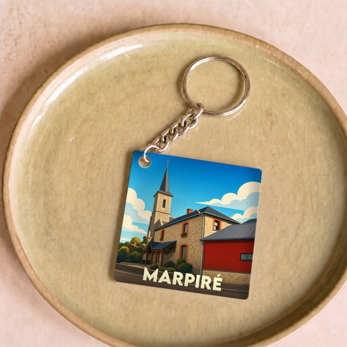 Porte-clés souvenir de la ville de Marpiré avec une illustration stylisée.