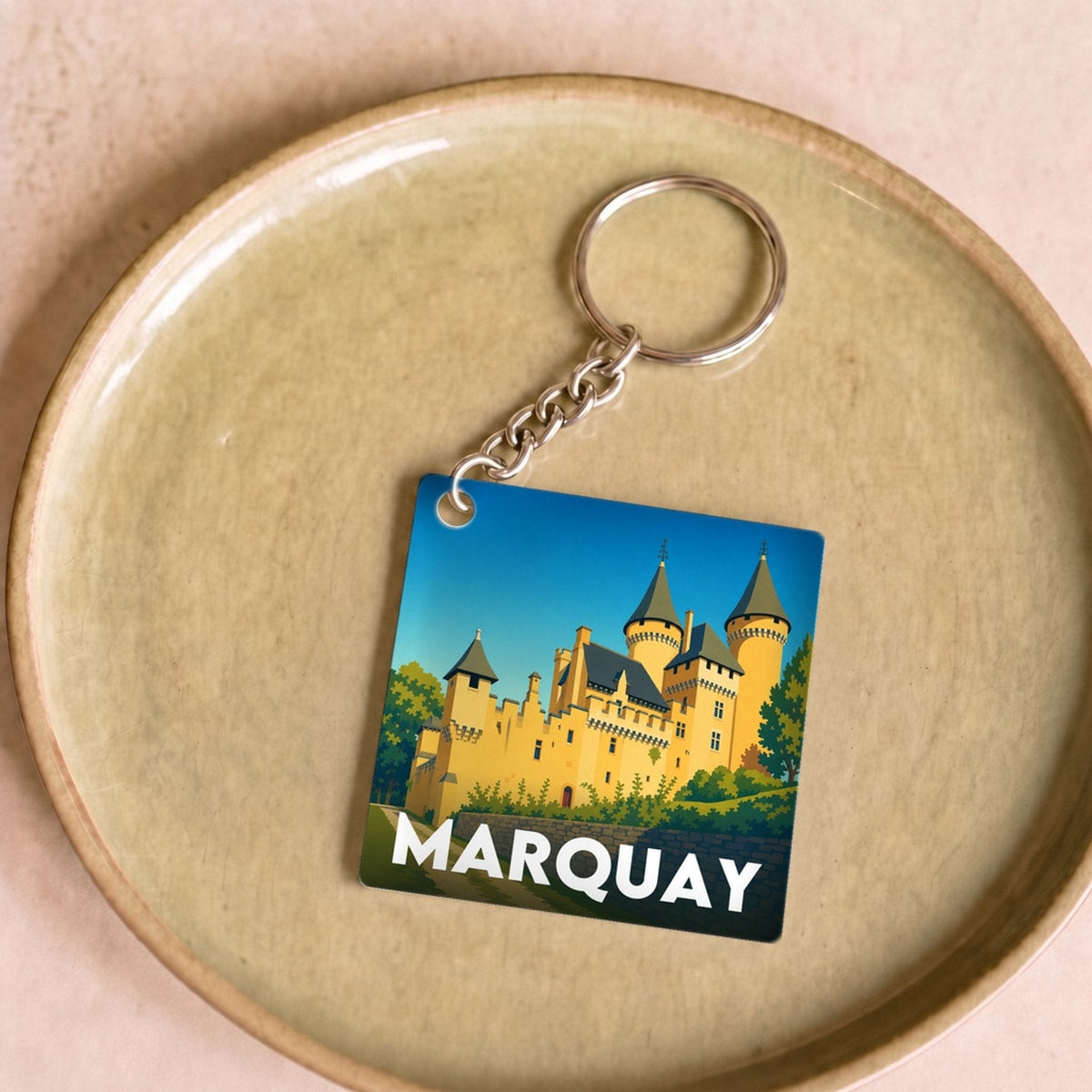 Porte-clés souvenir de la ville de Marquay avec une illustration stylisée d'un château.