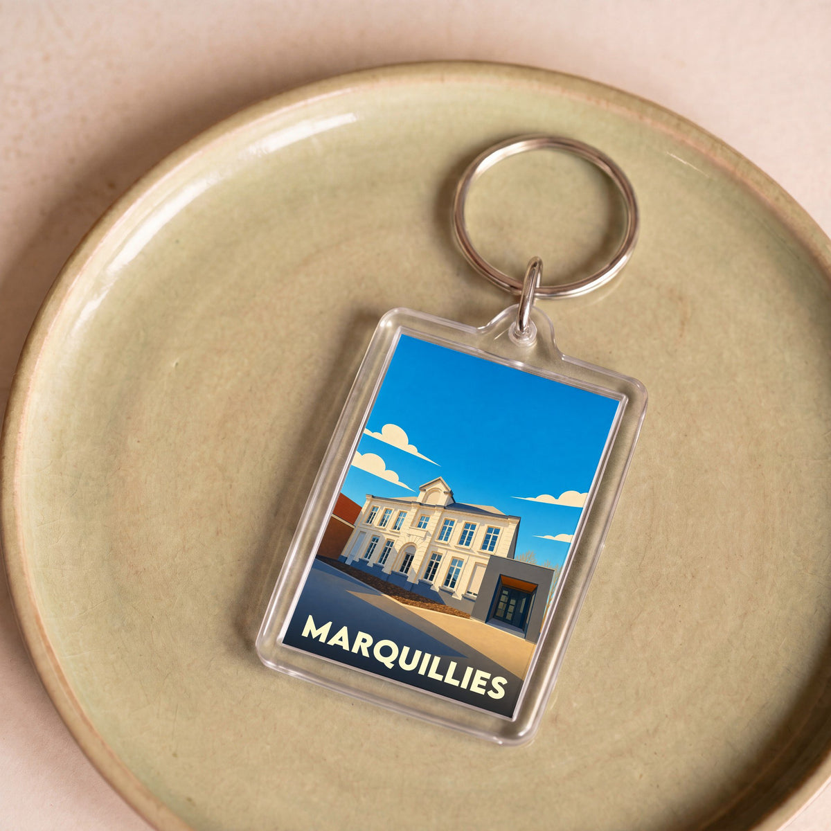 Porte-clés souvenir de la ville de Marquillies avec une illustration stylisée de l'hôtel de ville.