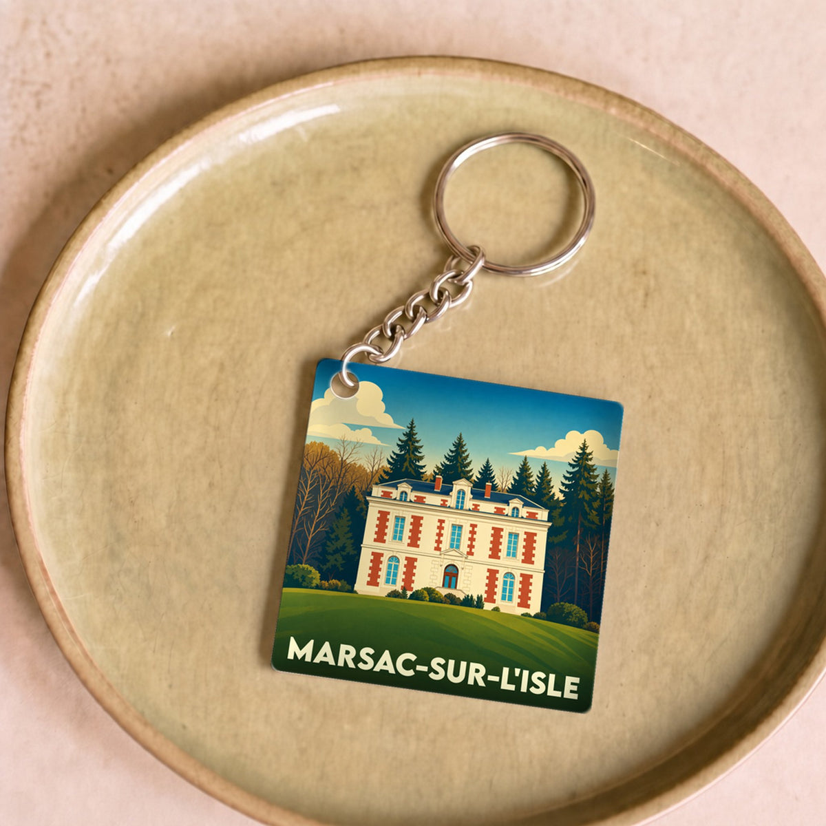 Porte-clés souvenir de la ville de Marsac-sur-l'Isle avec une illustration stylisée d'un château.