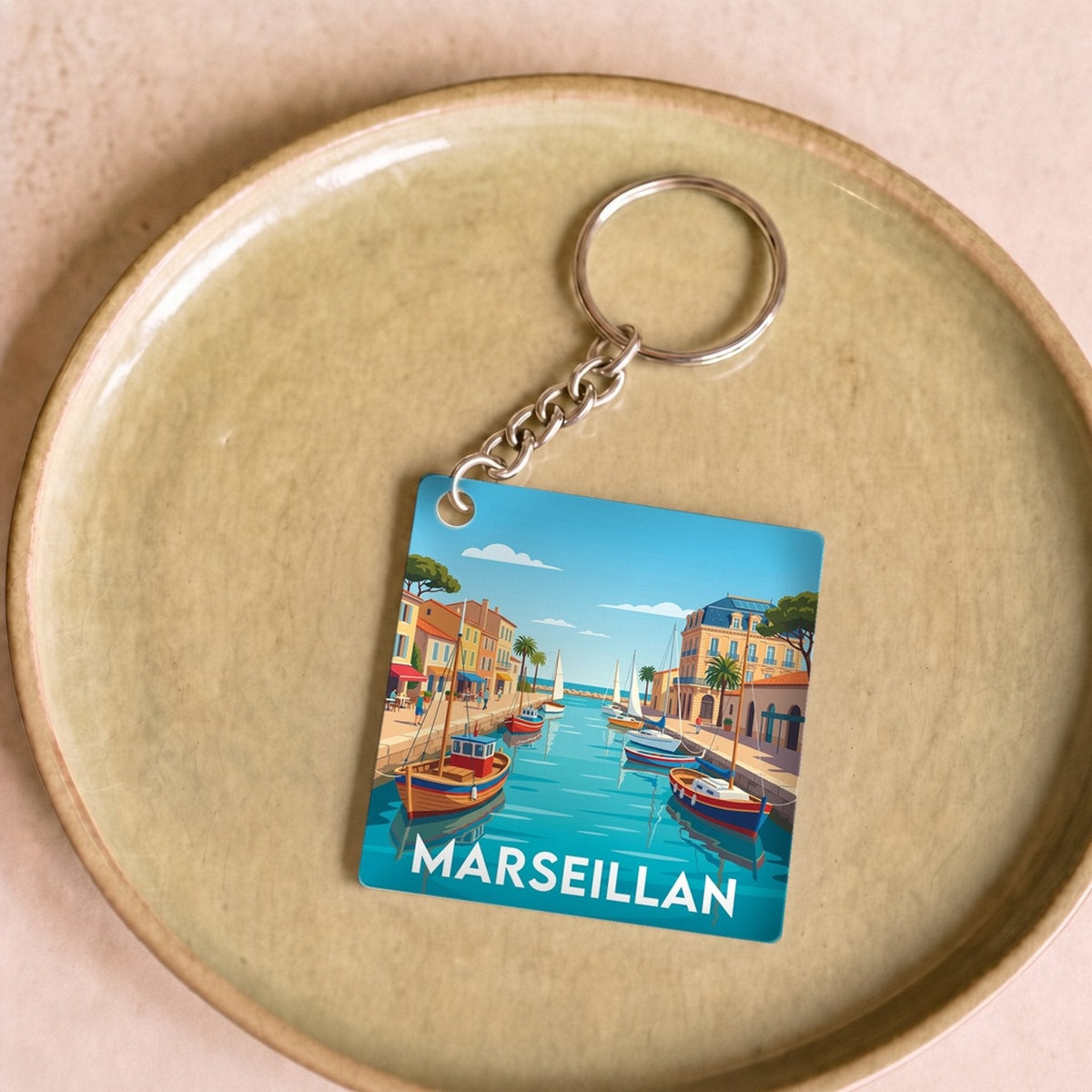 Porte-clés souvenir de la ville de Marseillan avec une illustration stylisée de son port.