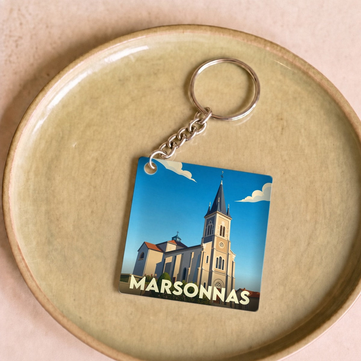 Porte-clés souvenir de la ville de Marsonnas avec une illustration stylisée de son église.
