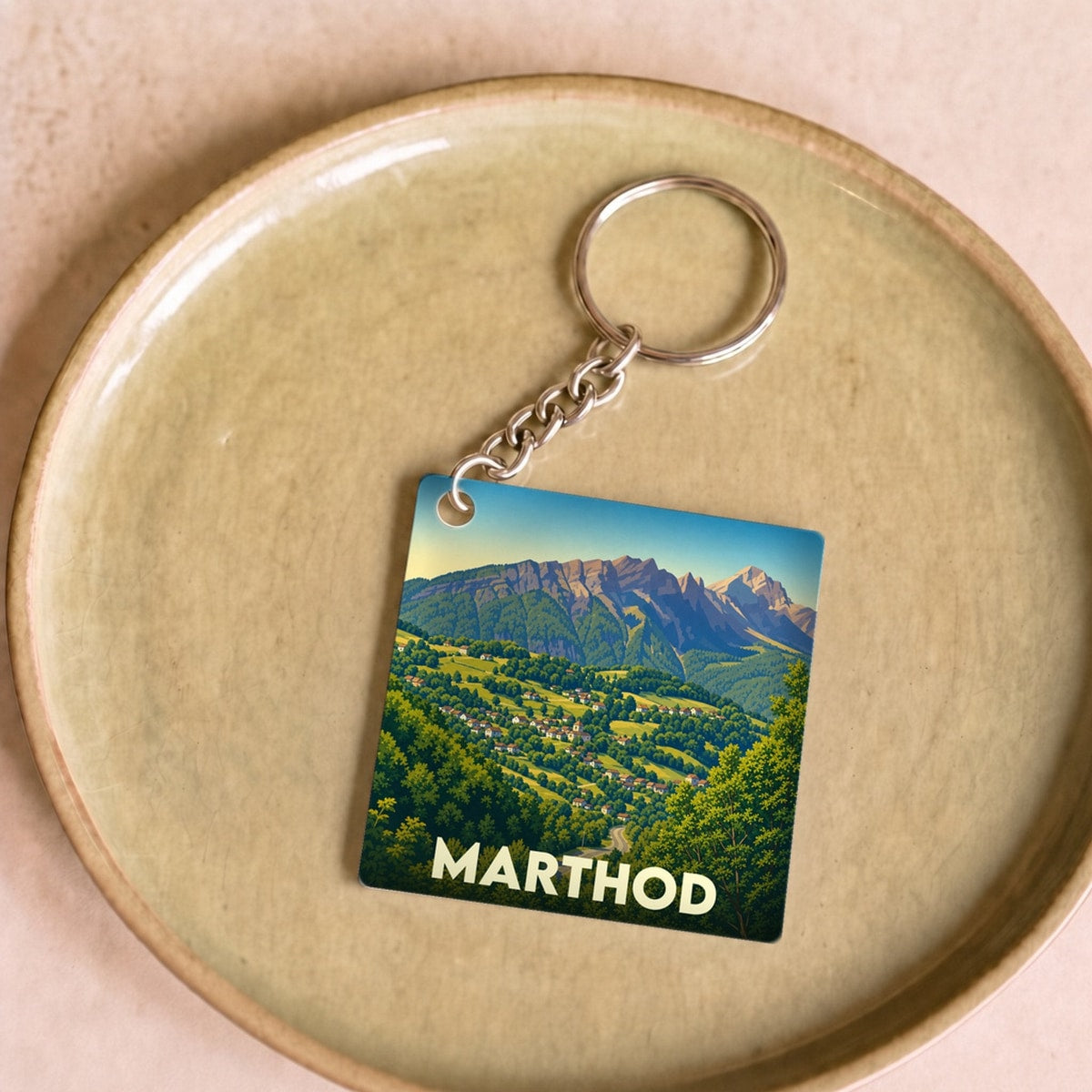 Porte-clés souvenir de la ville de Marthod avec une illustration stylisée de ses paysages montagneux.