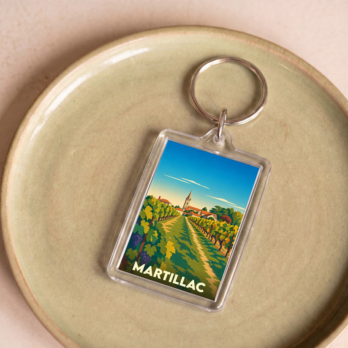 Porte-clés souvenir de la ville de Martillac avec une illustration stylisée de vignobles.