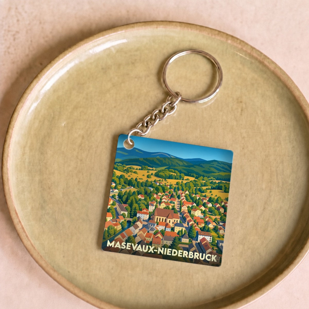 Porte-clés souvenir de la ville de Masevaux-Niederbruck avec une illustration stylisée.