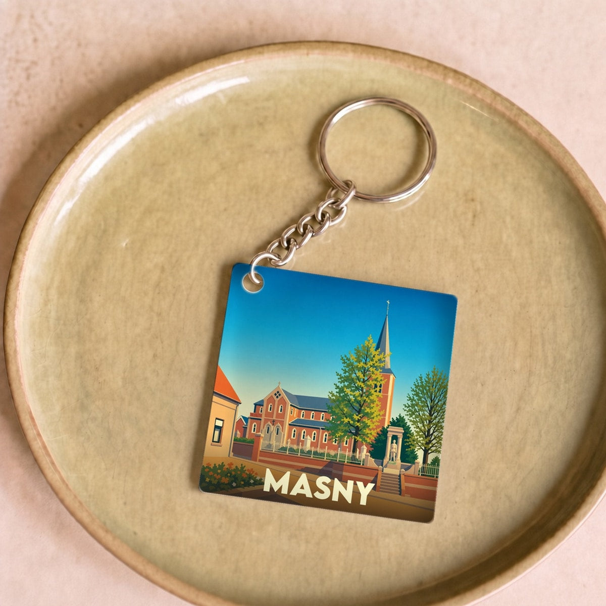 Porte-clés souvenir de la ville de Masny avec une illustration stylisée.