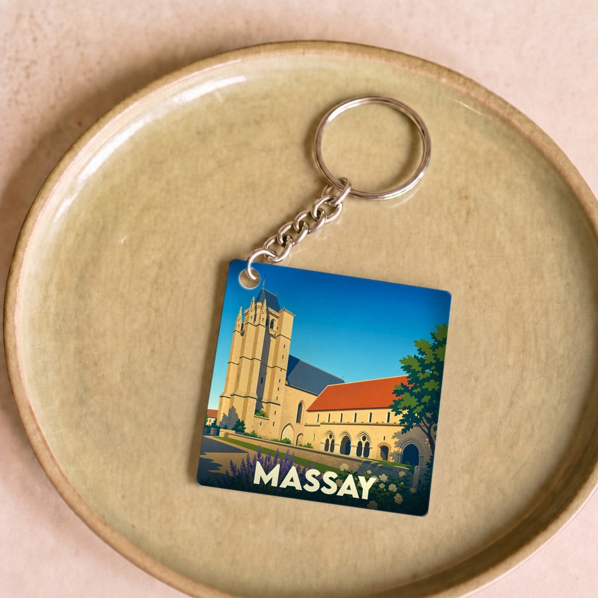 Porte-clés souvenir de la ville de Massay avec une illustration stylisée de son église abbatiale.
