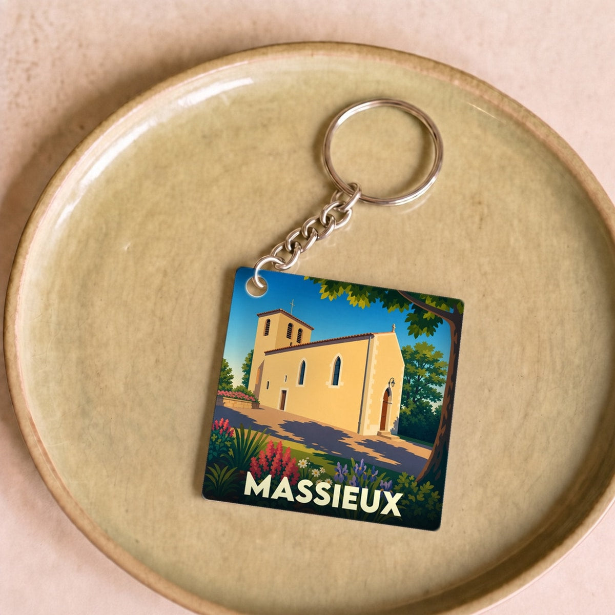 Porte-clés souvenir de la ville de Massieux avec une illustration stylisée de son église.