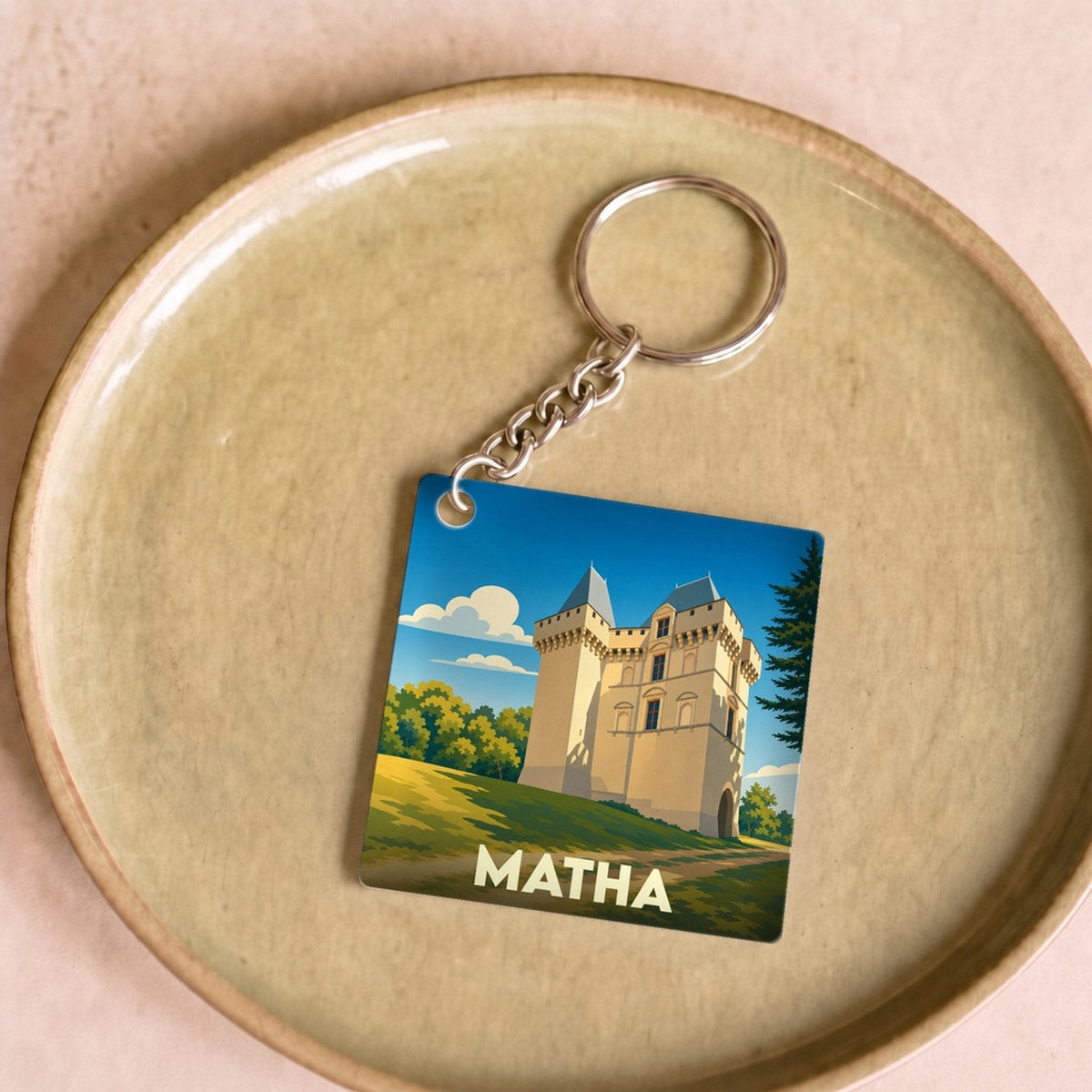 Porte-clés souvenir de la ville de Matha avec une illustration stylisée de son château.