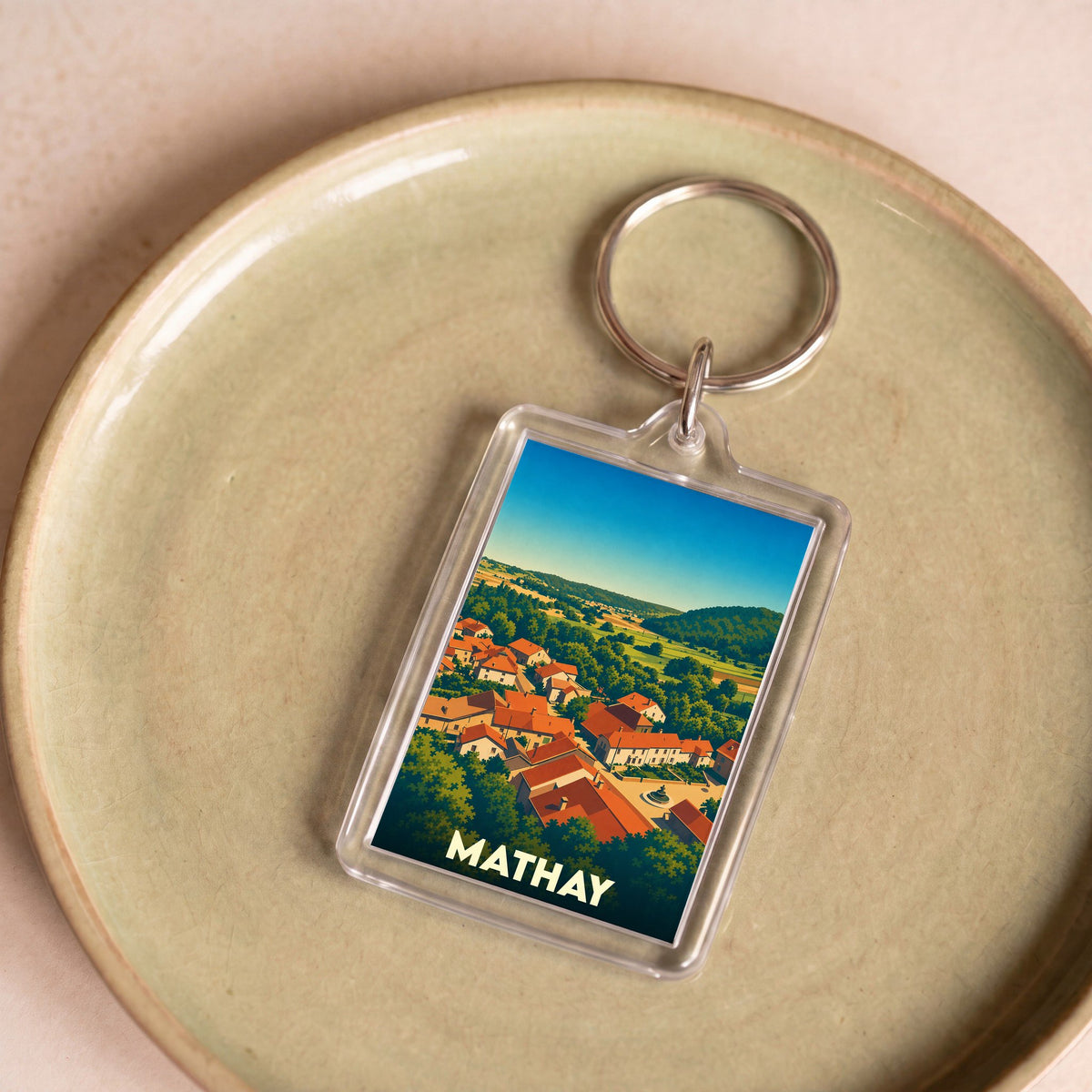 Porte-clés souvenir de la ville de Mathay avec une illustration stylisée.