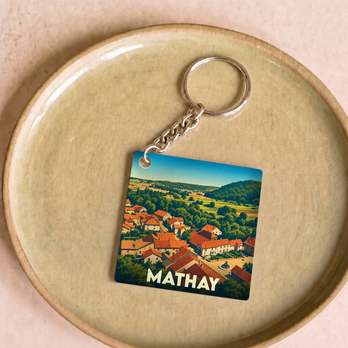 Porte-clés souvenir de la ville de Mathay avec une illustration stylisée.