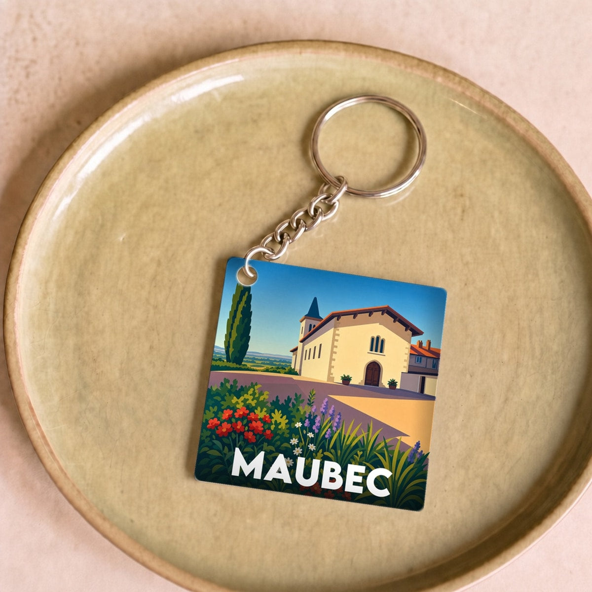 Porte-clés souvenir de la ville de Maubec avec une illustration stylisée et colorée.