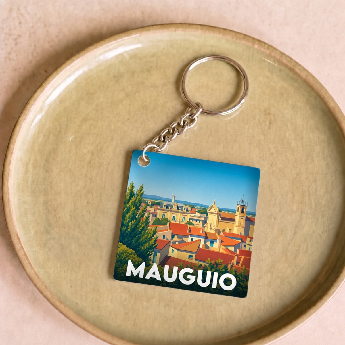 Porte-clés souvenir de la ville de Mauguio avec une illustration stylisée.