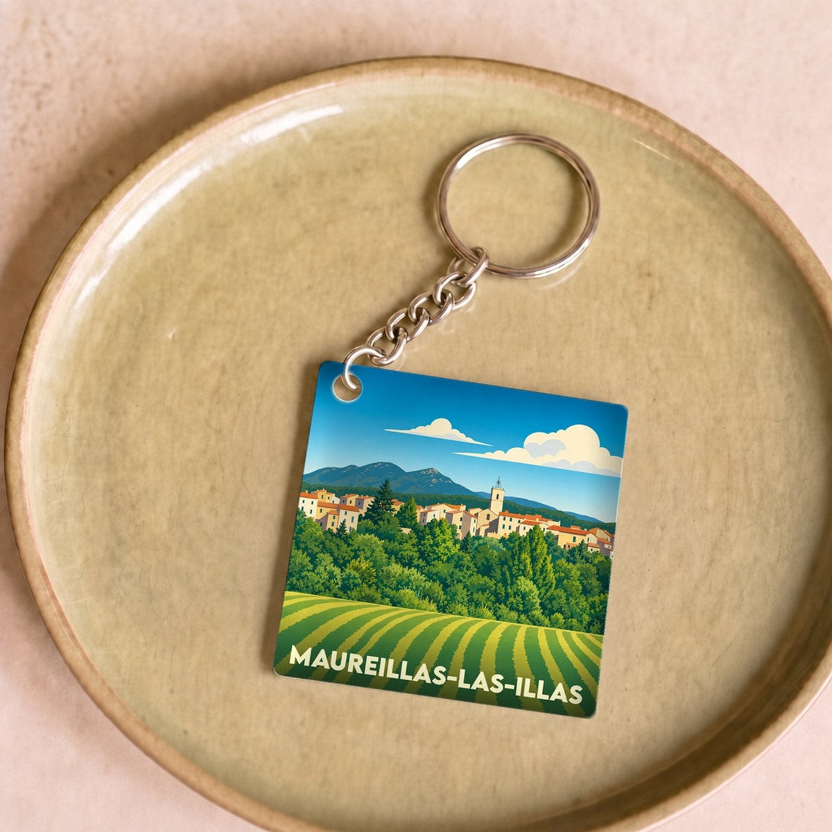 Porte-clés souvenir de la ville de Maureillas-las-Illas avec une illustration stylisée de son paysage.