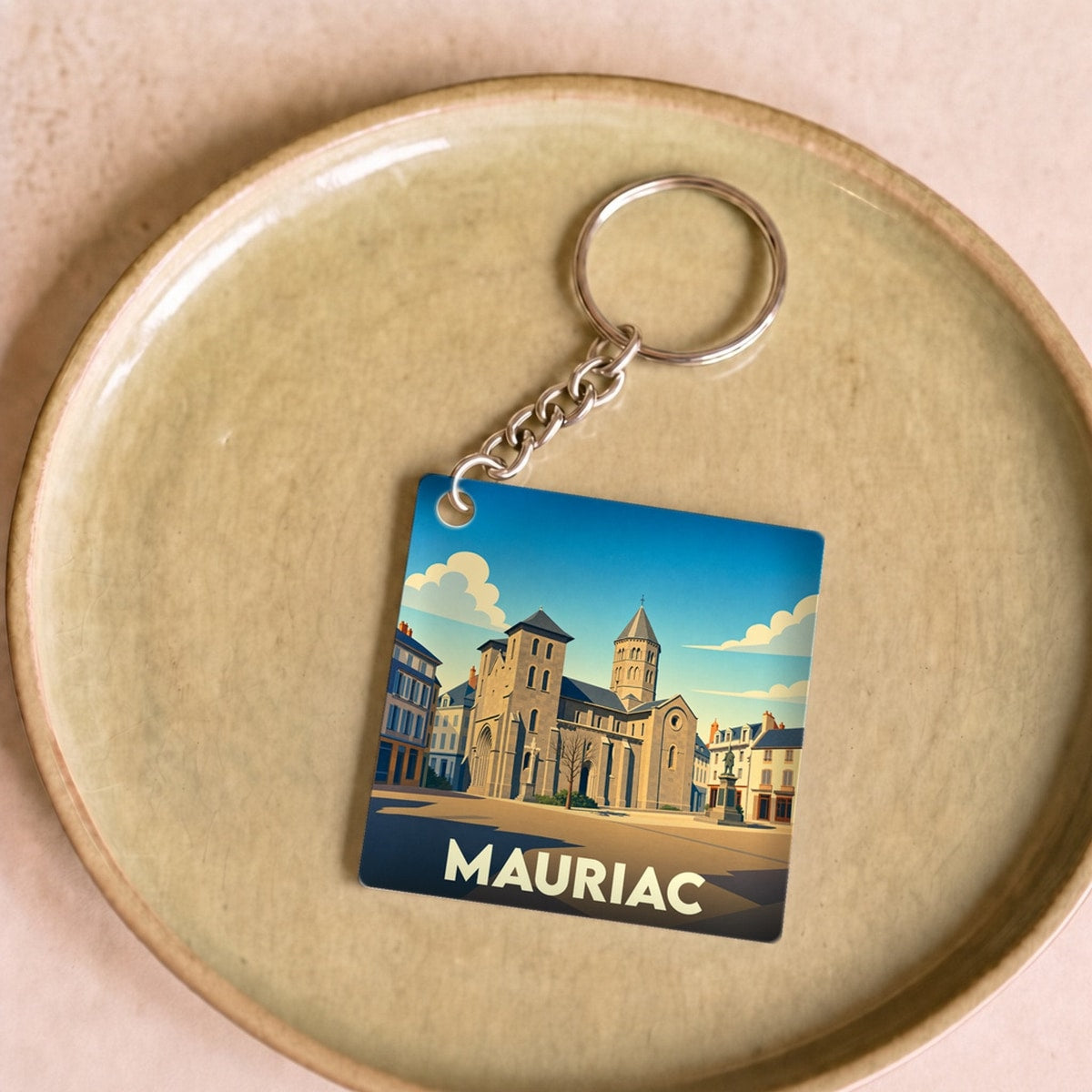 Porte-clés souvenir de la ville de Mauriac avec une illustration stylisée.