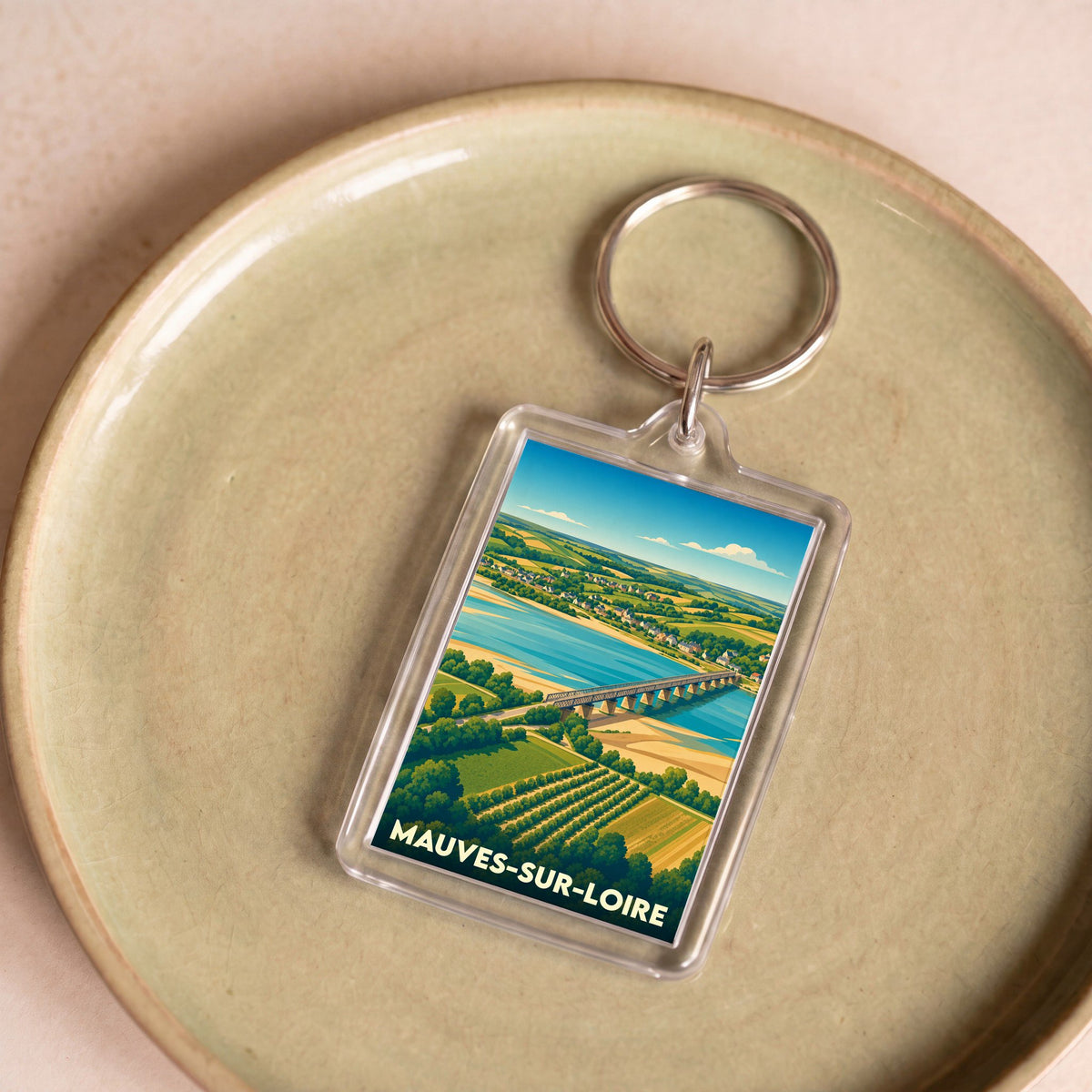 Porte-clés souvenir de la ville de Mauves-sur-Loire avec une illustration stylisée d'un pont traversant la Loire.