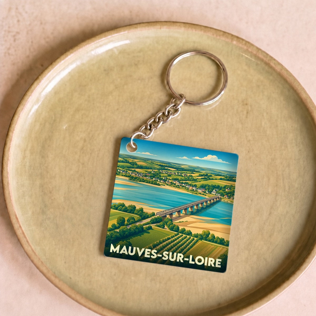 Porte-clés souvenir de la ville de Mauves-sur-Loire avec une illustration stylisée d'un pont traversant la Loire.