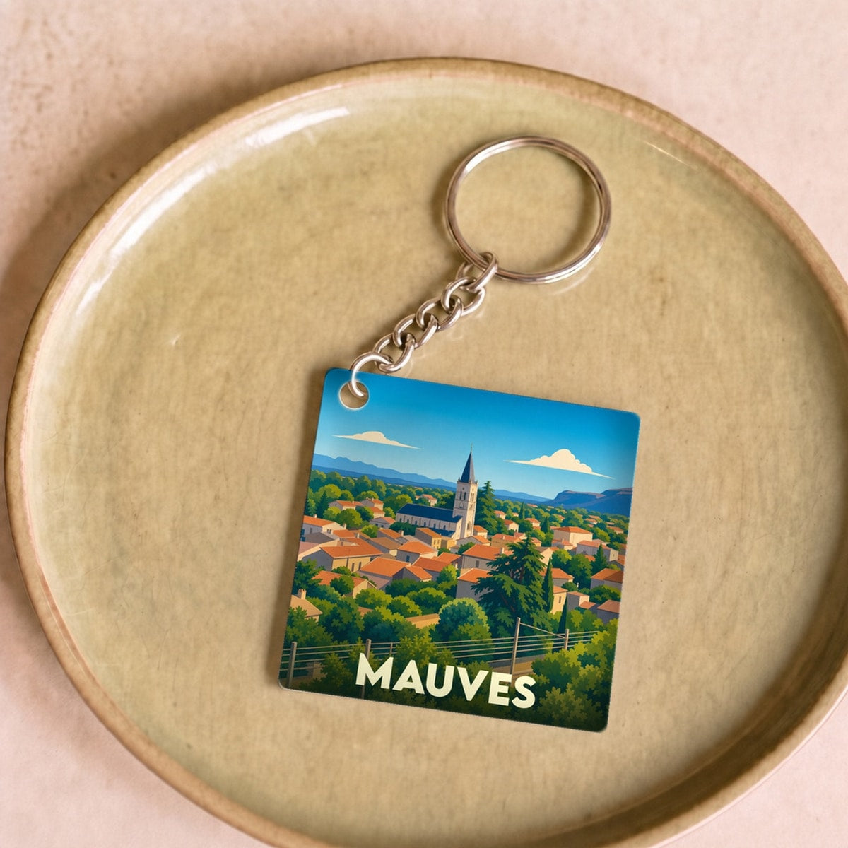 Porte-clés souvenir de la ville de Mauves avec une illustration stylisée.