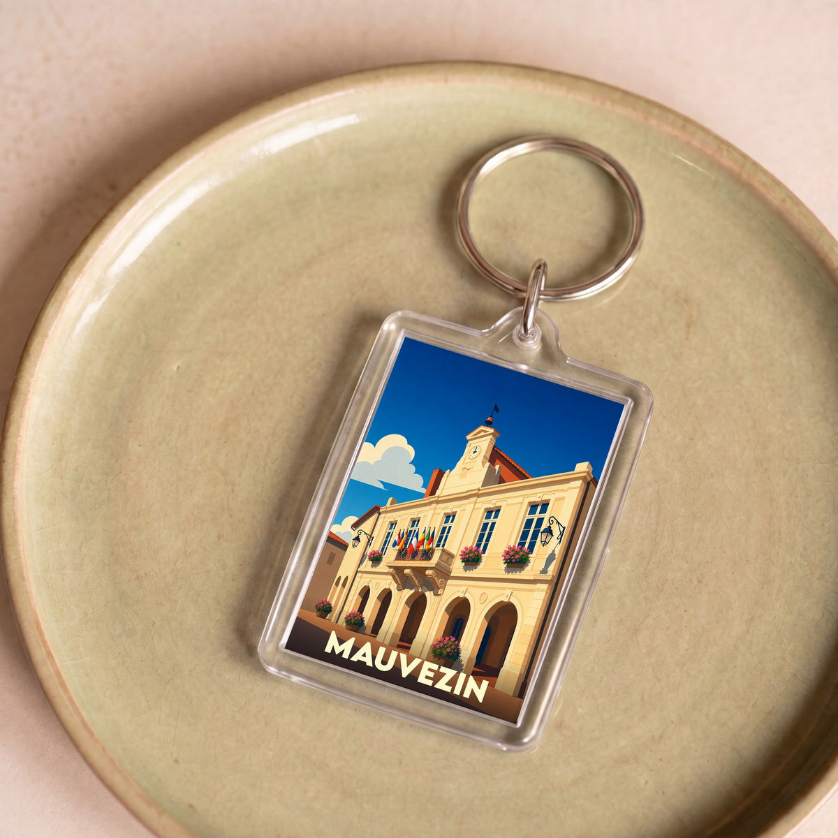 Porte-clés souvenir de la ville de Mauvezin avec une illustration stylisée de son hôtel de ville.