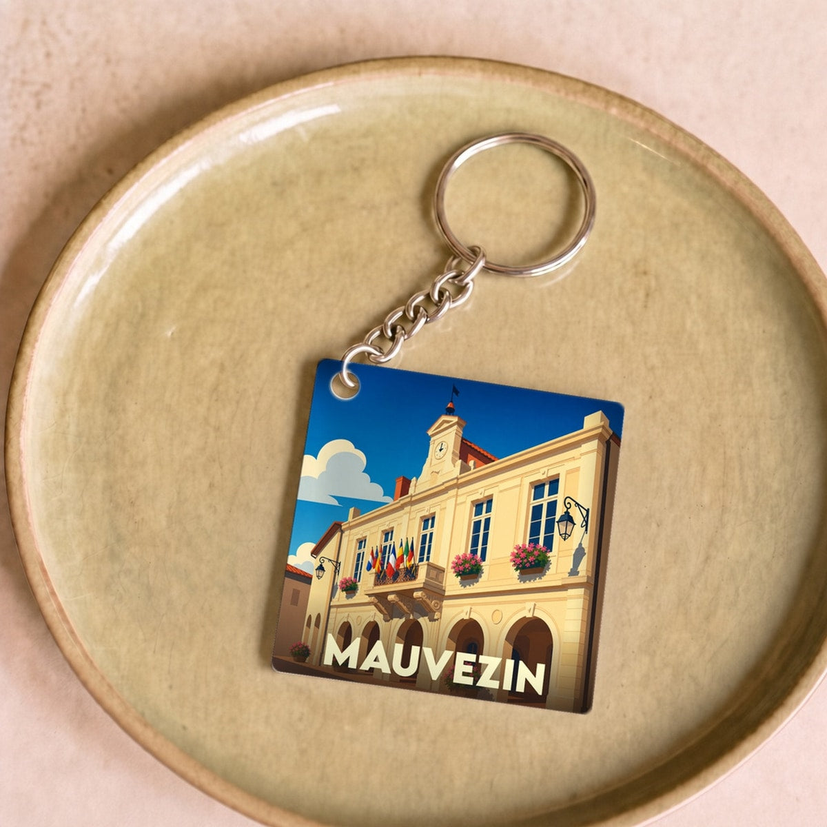 Porte-clés souvenir de la ville de Mauvezin avec une illustration stylisée de son hôtel de ville.