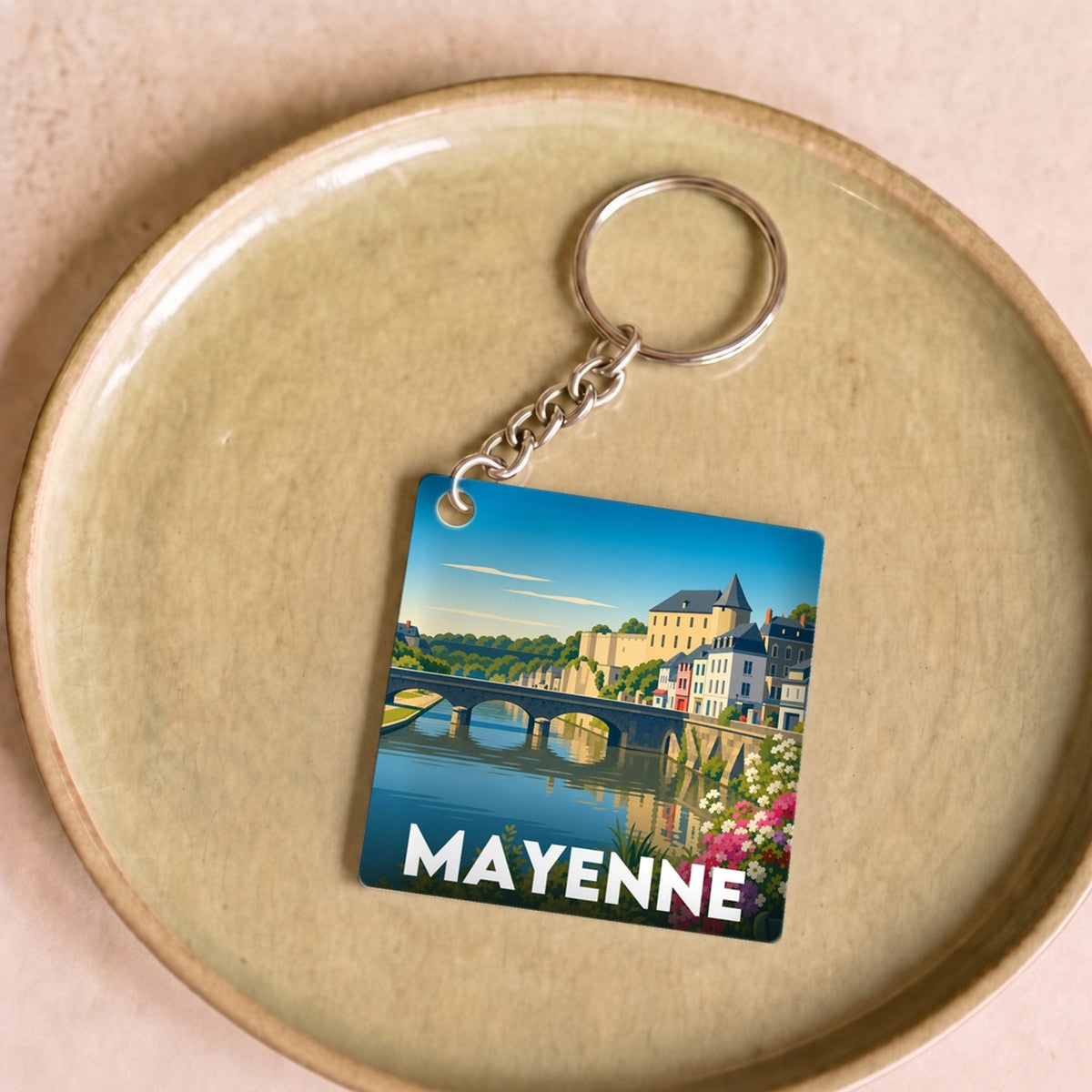 Porte-clés souvenir de la ville de Mayenne avec une illustration stylisée.